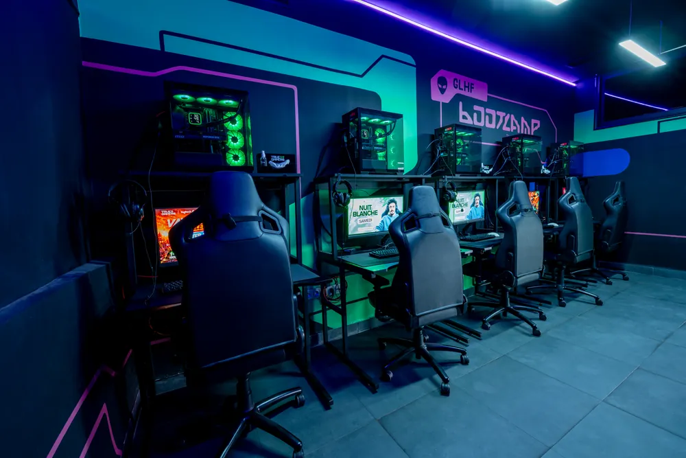 Salle de jeu True Gamers supervisée — rangée de stations PC